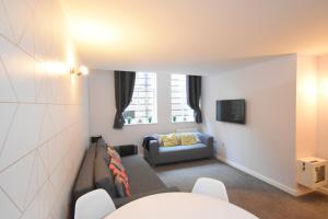 a living room with a couch and a chair at The Bootlace Apartment in Leicester