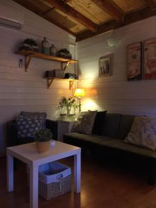 ein Wohnzimmer mit einem Sofa und einem Tisch in der Unterkunft Casaviacomo Chalets in Porlezza