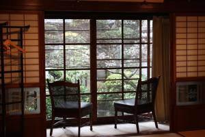 two chairs sitting in front of a window at Guesthouse Naramachi in Nara