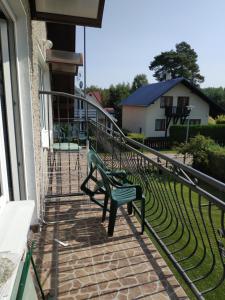 zielona ławka siedząca na ganku domu w obiekcie Familia w Rowach