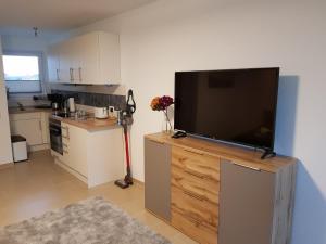 ein Wohnzimmer mit einem Flachbild-TV auf einem Entertainment-Center in der Unterkunft Fewo-Elbsicht-405 in Cuxhaven