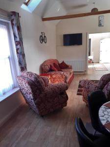 a living room with two chairs and a couch at Saracens Head Old Function Room in Chapel Saint Leonards