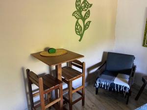 a table and chairs and a chair with a plate on it at Toca dos Pássaros in Boicucanga