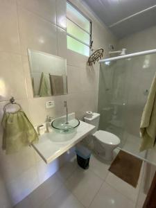 a bathroom with a sink and a toilet and a shower at Toca dos Pássaros in Boicucanga