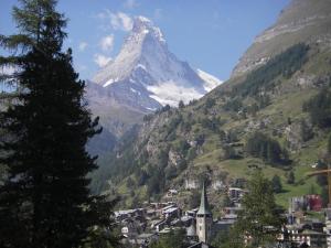 a view of a mountain with a town and a church at Haus Oasis in Zermatt