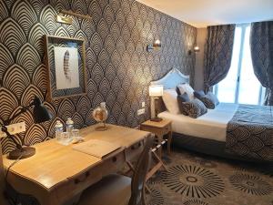 Cette chambre comprend un lit, un bureau et une table. dans l'établissement Hotel Le Lion D'Or et Restaurant La Table Du Lion, à Bayeux