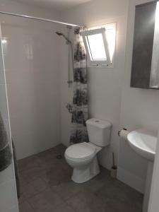 a white bathroom with a toilet and a sink at Castillo Mar 87 in Caleta De Fuste +29 photos