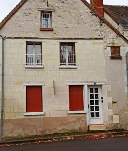 Cette ancienne maison en pierre est dotée de portes et de fenêtres rouges. dans l'établissement A 4 min du Zoo de Beauval La Maison à Partager Ch1, à Saint-Aignan