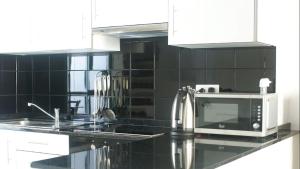 a kitchen with a sink and a microwave at Castillo Mar 87 in Caleta De Fuste