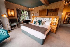 um quarto grande com uma cama grande e um sofá em The Maynard em Grindleford Bridge