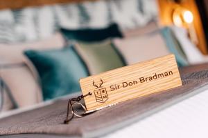 Uma etiqueta que diz "Sente-se Don Braddock sentado numa cama" em The Maynard em Grindleford Bridge