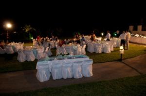 a group of tables set up for a wedding at night at ilyda Residence apts in Skala Kallonis +69 photos