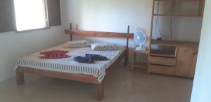 a bedroom with a bed and a desk with a fan at Sem Fronteiras in Ilha de Boipeba