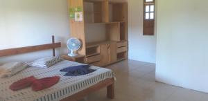 a bedroom with a bed with a fan on it at Sem Fronteiras in Ilha de Boipeba