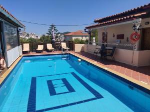 a large swimming pool with blue water in a house at Taxiarchis Apartments in Skiathos