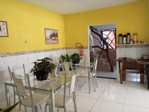 a dining room with tables and chairs and a yellow wall at Pousada da Lurdinha in Lençóis