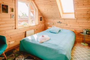 een slaapkamer met een bed in een houten kamer bij Albireo in Talsi