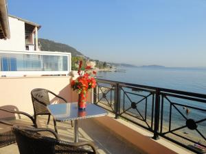 a table with a vase of flowers on a balcony at Galini Sea Apartments in Benitses