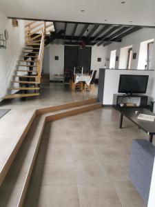 a living room with a tv and a staircase at maison du bonheur de la basse biguerie proche du zoo de la flèche in Saint-Jean-de-la-Motte