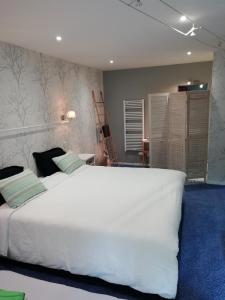 1 dormitorio con 1 cama blanca grande y alfombra azul en La Grange d'Amfreville en Amfréville