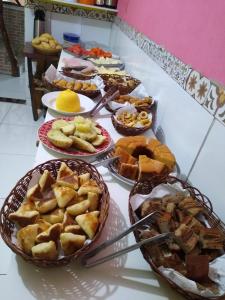 une table avec de nombreuses assiettes de nourriture dans l'établissement Pousada da Lurdinha, à Lençóis