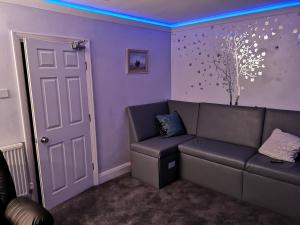 a living room with a couch and a tree on the wall at The Rufford Hotel in Skegness