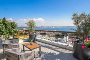 einen Balkon mit Stühlen, einem Tisch und Blick auf das Wasser in der Unterkunft Hotel Poem in Istanbul