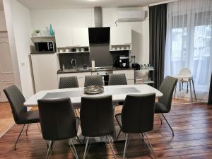 a kitchen and dining room with a table and chairs at Freedom Apartman in Hajdúszoboszló