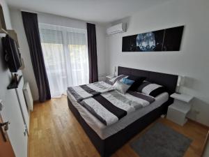 a bedroom with a large bed in front of a window at Freedom Apartman in Hajdúszoboszló