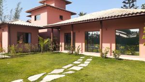 a pink house with a pathway in front of it at Hospedaria Oitis in Búzios