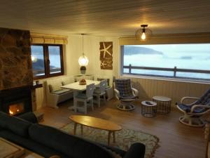 Una sala de estar con chimenea y una mesa y sillas. en La Cabaña de la playa, en Ajo