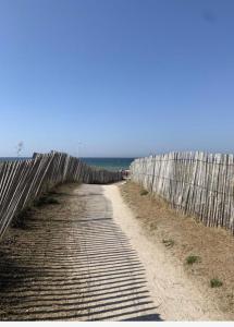 a wooden fence on the side of a beach at Appartement Cabourg bord de mer in Cabourg