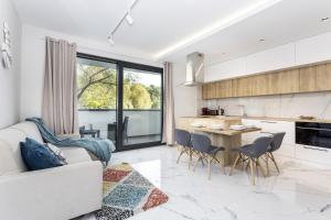 a kitchen and living room with a couch and a table at Natural Hel Apartamenty in Hel