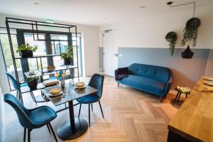 een woonkamer met een blauwe bank en een tafel bij Boutique B&B Oud Aa in Breukelen