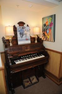 an old piano in a room with two lamps at Smugglers Cove Inn in Lunenburg