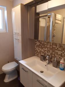 a bathroom with a white sink and a toilet at Apartments Pavelic in Novi Vinodolski