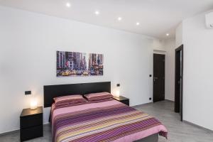una camera da letto con un grande letto con due comodini di Il mondo in una stanza a Genova