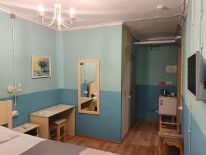 クラスノゴルスクにあるHotel Kofeynya Pribrejnayaのベッド、デスク、鏡が備わる客室です。