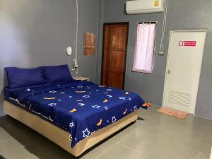 a bedroom with a bed with a blue comforter at Bedtime Story in Mae Sai