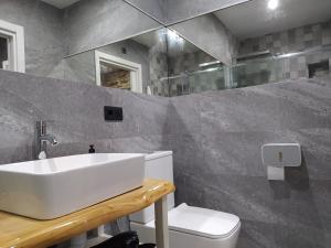 a bathroom with a sink and a toilet at Apartamentos turísticos o palomar in Villalba