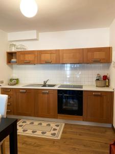 a kitchen with wooden cabinets and a black dishwasher at Appartamento San Pellegrino in Passo San Pellegrino