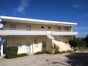 un edificio amarillo con escaleras a un lado en Kalypso relaxing shelter, en Arkitsa