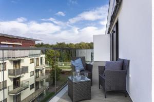 a balcony with two chairs and a table on a building at Natural Hel Apartamenty in Hel