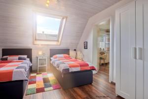 1 dormitorio con 2 camas y ventana en Ferienhaus Werner, en Liebenburg