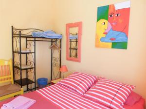 a bedroom with a bed and a painting on the wall at Casa do Lado in Carrapateira