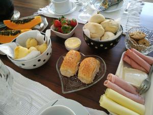 a table topped with bowls of bread and other foods at Agellum Bed & Breakfast in Domingos Martins