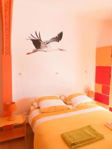een vogel die boven een bed vliegt in een slaapkamer bij Casa do Lado in Carrapateira