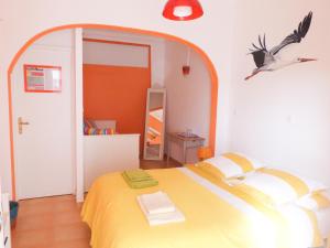 a bedroom with a yellow bed and a bird on the wall at Casa do Lado in Carrapateira