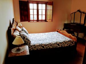a bedroom with a bed and a table with a lamp at Casa do Rebelhe in Bragança