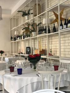 a dining room with white tables and bottles of wine at Acquapazza Restaurant & Room in San Benedetto del Tronto